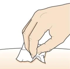 Una mano tiene un fazzoletto bianco per pulire o tamponare una zona di pelle chiara e liscia