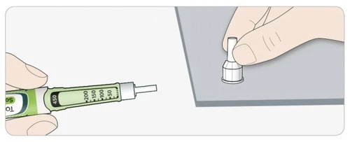 A hand holding a green and white injection pen while the