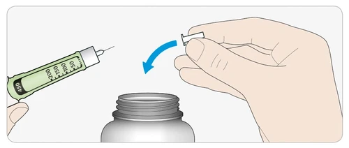 A hand holding a graduated syringe while the