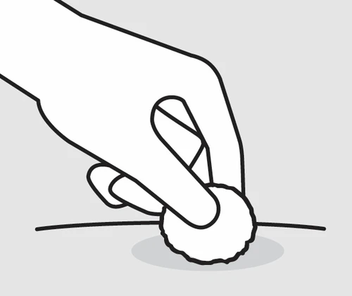 Una mano sostiene una pequeña bola de algodón o gasa y la presiona suavemente sobre una herida o un punto específico de la piel