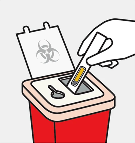 Una mano introduce una prueba diagnóstica con tira amarilla en un contenedor rojo para residuos biológicos con símbolo de riesgo biológico