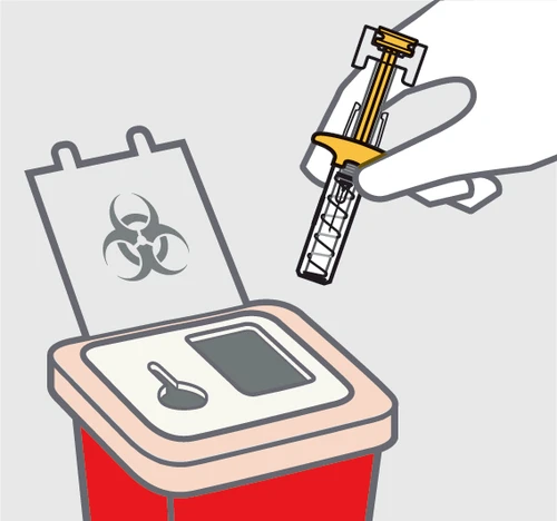 Una mano introduce una jeringa usada en un contenedor rojo para residuos biológicos con símbolo de riesgo biológico en la tapa blanca