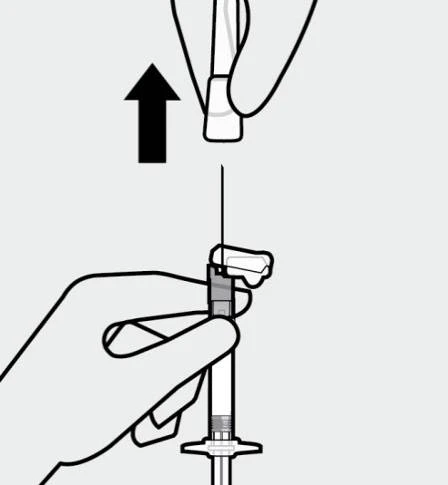 Una mano solleva verticalmente un cappuccio bianco da un ago collegato a una siringa medica con una freccia nera rivolta verso l'alto