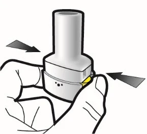 Two hands holding a cylindrical white medical device with black arrows indicating a rotational or lateral pressure movement