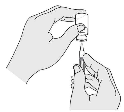Two hands preparing the medication: one holds a glass vial while the other