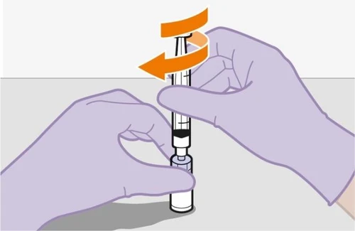 Two gloved hands holding a syringe with dark liquid while an orange arrow indicates a rotational movement upward