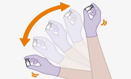 Gloved hands rotating a medication vial clockwise following a curved orange arrow indicating agitation movement