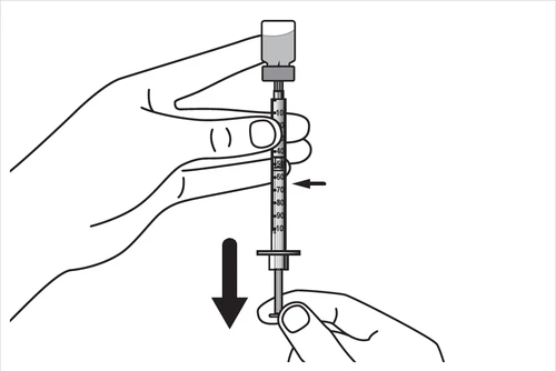 A hand holding the upper part of a syringe with a vial while another component is being adjusted