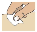 One hand holding and applying a small white gauze pad to the skin of an arm or leg