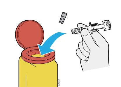 A hand inserts a gray cylindrical cap over the top of a yellow syringe following the direction of a blue arrow