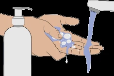 Mani che si lavano con sapone sotto un getto d'acqua che esce da un rubinetto accanto a un flacone dosatore bianco