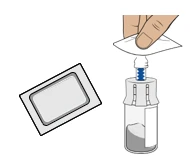 Una mano preme un tappo bianco su un flaconcino di vetro contenente polvere grigia per preparare il farmaco