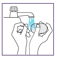 Due mani lavano un pezzo di sapone sotto il getto d'acqua che esce da un rubinetto aperto in un lavandino