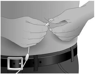 Two hands holding a small medical device on the abdomen of a person wearing a shirt and a belt with a metal buckle