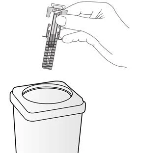 A hand holds a syringe ready for