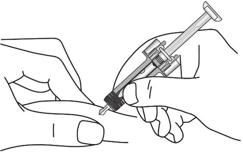 A hand holds a syringe at an angle while the