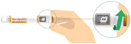 A hand holds a white and orange medical device with a magnification showing a green arrow pointing toward the