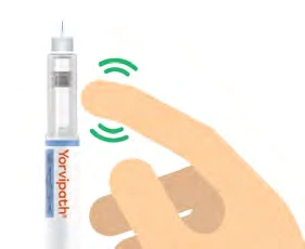 A hand holds a pre-filled syringe labeled Yorvipath while a finger touches the top with green waves indicating the