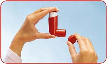 Dwie dłonie trzymają czerwony inhalator, jedna ręka trzyma korpus urządzenia, a druga odkręca małą, okrągłą nakrętkę z górnej części