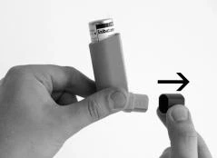A hand removes the protective cap from a medical device by sliding it to the right, indicated by a black arrow on a light background