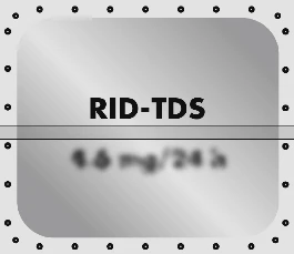 Szary prostokątny panel z czarnym napisem RID-TDS oraz rozmytym tekstem poniżej, otoczony rzędem małych czarnych kropek na jasnym tle
