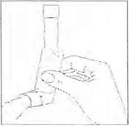 Hand holding vertically a glass vial of medication, while the other hand gently unscrews or opens its cap
