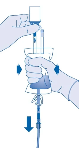 Mani con guanti blu montano una fiala di farmaco su un set per infusione, e frecce indicano la direzione di inserimento e il flusso del liquido
