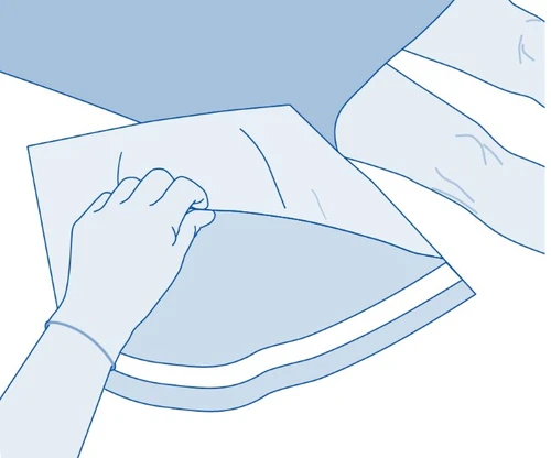 Mano con dita distese che apre un imballaggio piatto e bianco di forma rettangolare su sfondo chiario