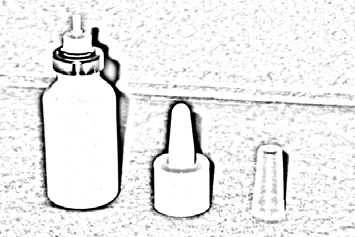Piccolo flacone bianco con erogatore e due elementi separati del tappo e della punta dell'applicatore disposti accanto su sfondo chiaro