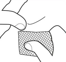Hand placing a square patch with a mesh pattern onto the skin, preparing the site for medication application