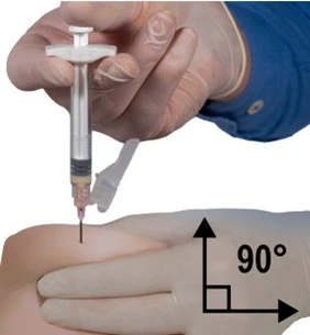 Mano con guante azul sosteniendo una jeringa e introduciendo la aguja en el muslo con un ángulo recto de 90 grados indicado por una flecha negra y el símbolo del ángulo
