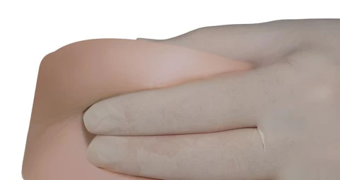 Primer plano de una mano con guante médico blanco que presiona suavemente y masajea la zona abdominal del paciente para la administración del medicamento