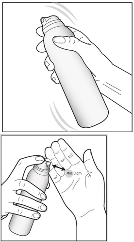 Mano agitando el bote de spray y otra mano sosteniendo el envase a una distancia mínima de 3 cm de la piel de la mano durante la aplicación del medicamento