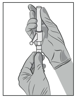 Two hands in medical gloves holding vertically a white injector with a small knob on the left side
