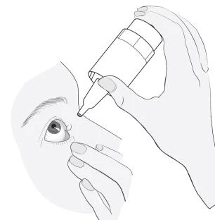 Mano sosteniendo un frasco pequeño con gotero, aplicando medicamento en el ojo de una persona que con la otra mano separa suavemente el párpado inferior