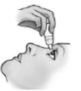 Hand holding a small dropper bottle, bringing its tip directly to the closed eye of a person shown in profile