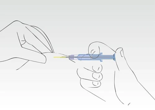 Manos sujetando la piel y el tejido, mientras otra mano introduce la aguja de la jeringa en ángulo hacia el cuerpo para administrar un medicamento
