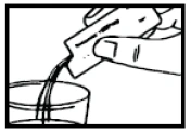 A hand holding an open sachet, from which a powdered substance or small granules are being poured into a glass of liquid