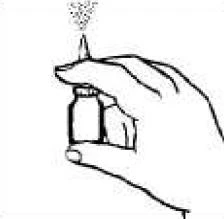 Hand holding a small bottle with a dispenser from which a fine mist of sprayed medication is being released upwards