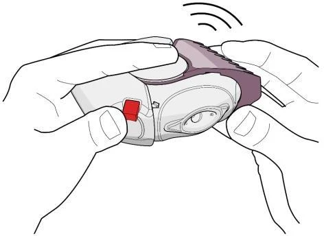 Two hands holding a white medical device with a red button, preparing it for use with visible signal lines above it