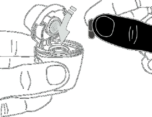 Hands holding a medical device, one hand stabilizing the base while a finger of the other hand presses the upper part with a visible directional arrow