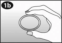 Hand holding a round, flat device with a distinct rim, depicted as a black-and-white schematic with label 1b in the upper left corner