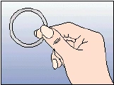 Right hand holding a thin, round ring between fingers against a light blue background
