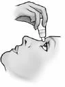 A hand holding a small dropper bottle administering medication directly into the closed eye of a person shown in profile