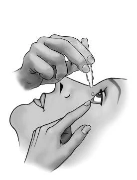 A hand holds a dropper from which a drop of medication falls into the eye of a person gently pulling down the lower eyelid with the other hand