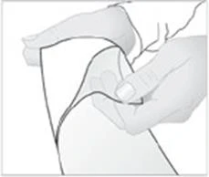 Two hands stretching and pulling apart a piece of light-colored elastic fabric or dressing to expose the underlying surface
