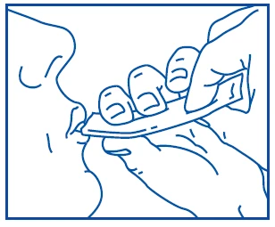 A blue line depicts the facial profile of a person placing a thin, rectangular tablet under the tongue, held by two hands