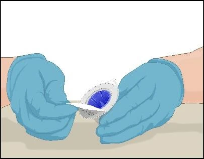 Hands wearing blue medical gloves holding and opening a white package containing a blue tablet or capsule