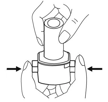 Two hands holding a medical device, the upper hand gripping the barrel and the lower hand pressing the sides of the housing with index fingers