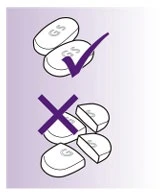 Dos tabletas completas blancas con la marca GS y un símbolo de verificación de color violeta, y tabletas partidas en fragmentos con una cruz de color violeta